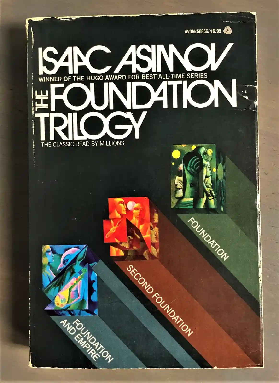 A vintage paperback cover of Isaac Asimov's 'The Foundation Trilogy' shows three books stacked diagonally, labeled…