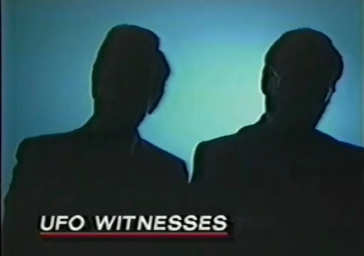 Two silhouetted figures in suits stand back-to-back against a blue background, with the text 'UFO WITNESSES' displayed at…