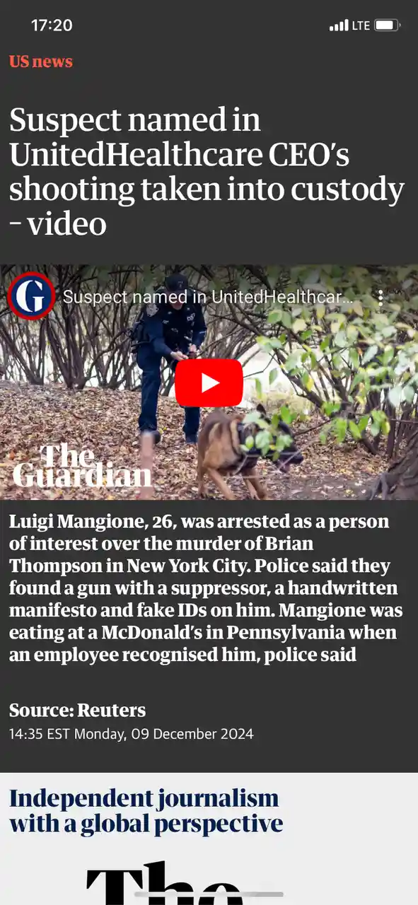 A screenshot of a mobile news article from The Guardian shows a police officer with a K-9 dog in a wooded area covered in…