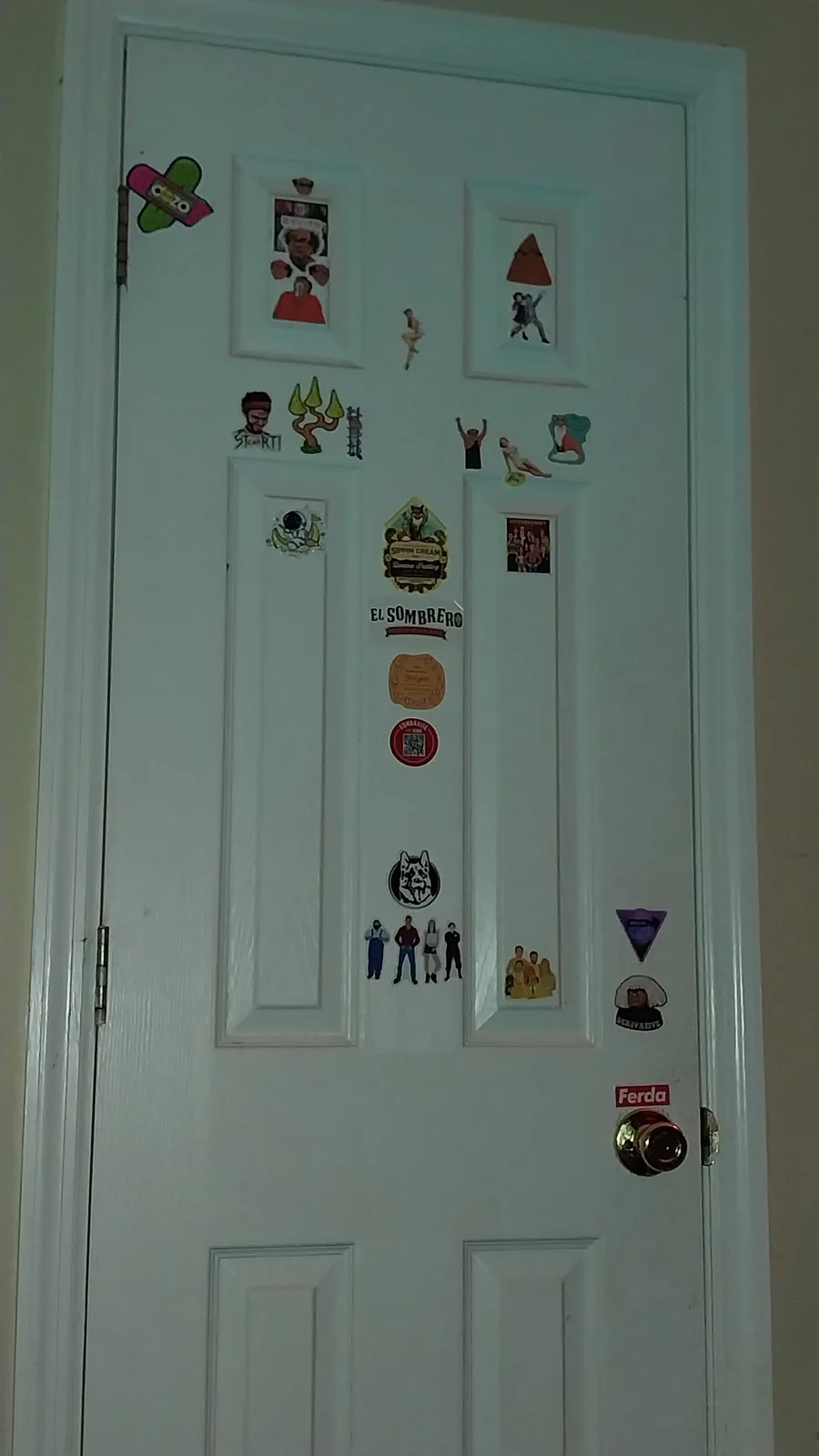 A white interior door is covered with numerous colorful stickers and magnets, including cartoon characters, movie posters…