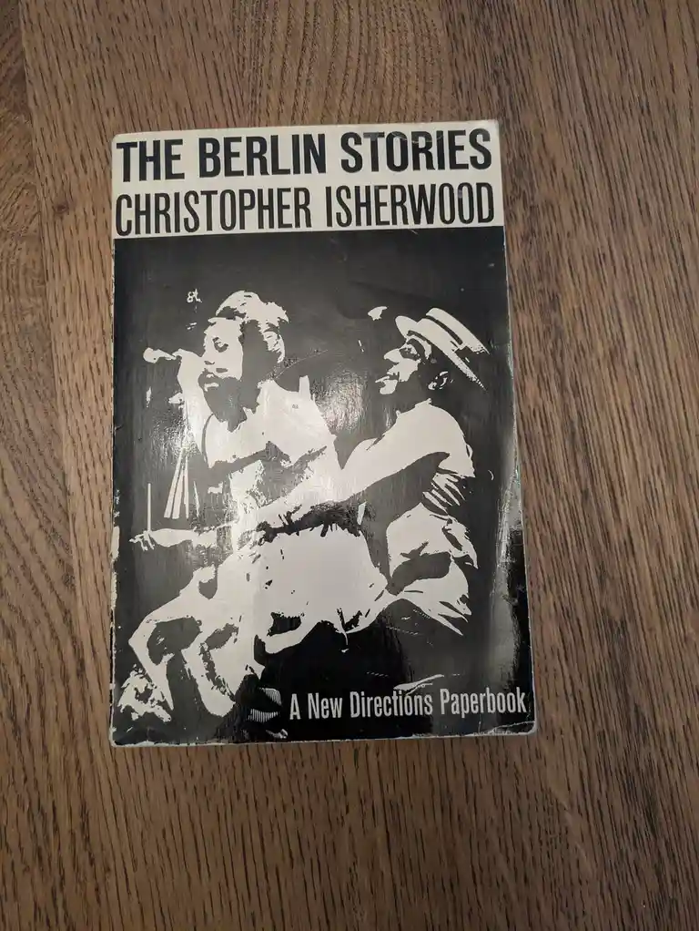 A black and white paperback book titled 'THE BERLIN STORIES' by Christopher Isherwood, featuring a stylized illustration of…