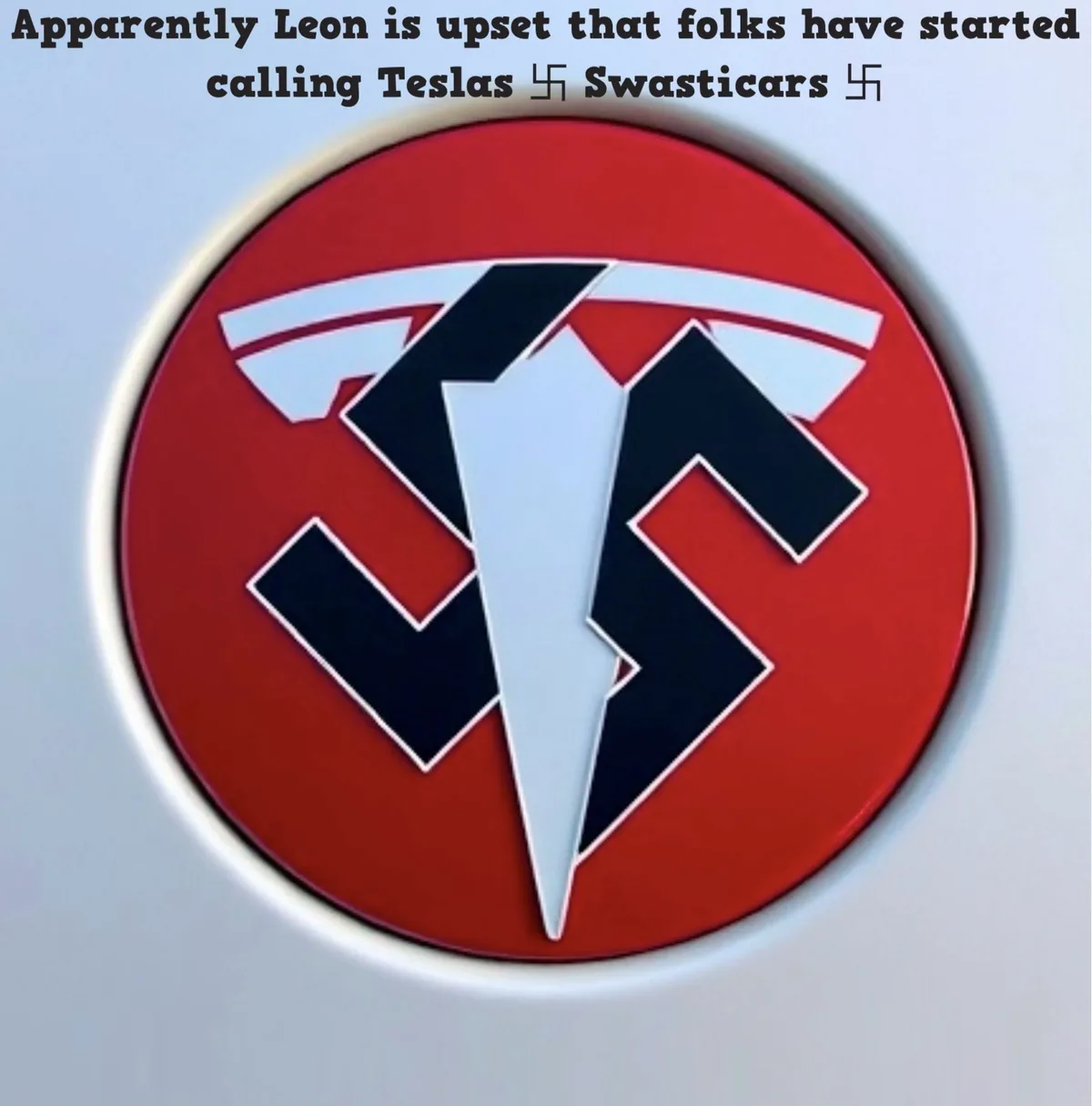 The image shows a close-up of a Tesla car emblem, but the logo has been digitally altered to resemble a swastika, with red…