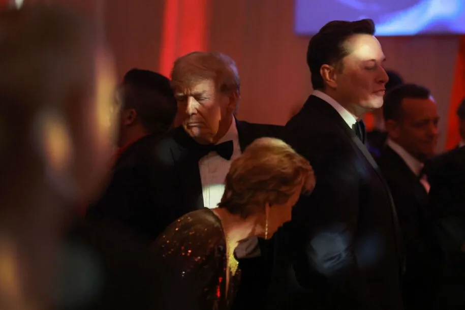 A photo shows Donald Trump and Elon Musk standing side-by-side at a formal event, both in tuxedos, with Trump looking…