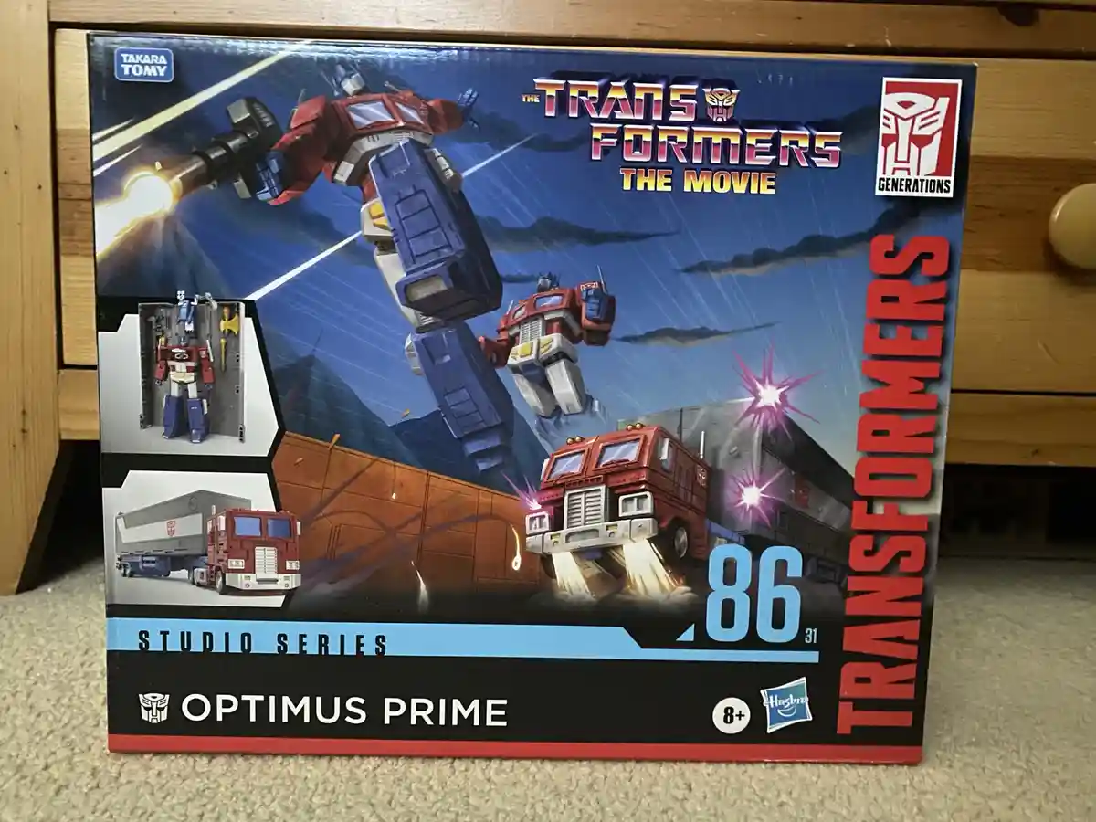 A Transformers toy box for Optimus Prime from 'The Transformers: The Movie' Studio Series, featuring artwork of Optimus…