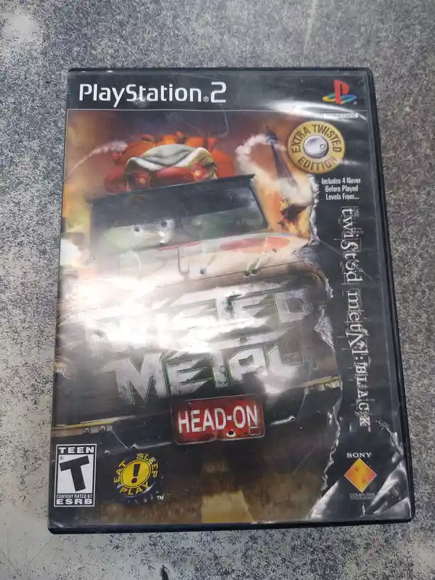 A PlayStation 2 game case for 'Twisted Metal: Head-On' shows a heavily damaged car with a cartoonish, angry face and a…