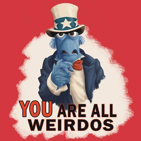 A blue Muppet character dressed as Uncle Sam, wearing a top hat with stars and stripes, a blue suit, and a red bowtie…