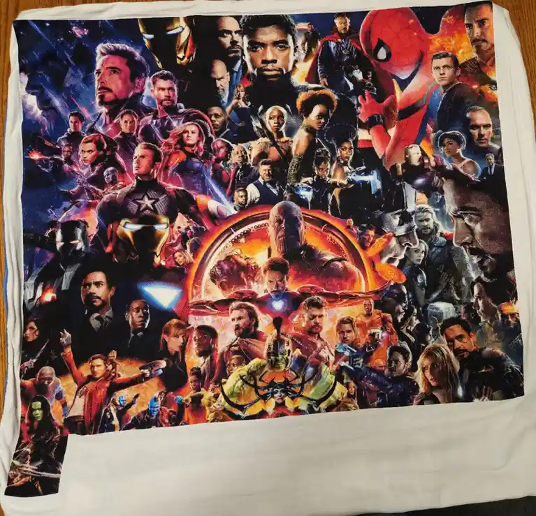 A white towel displays a dense collage of Marvel superhero characters from the 'Avengers: Endgame' movie poster, including…