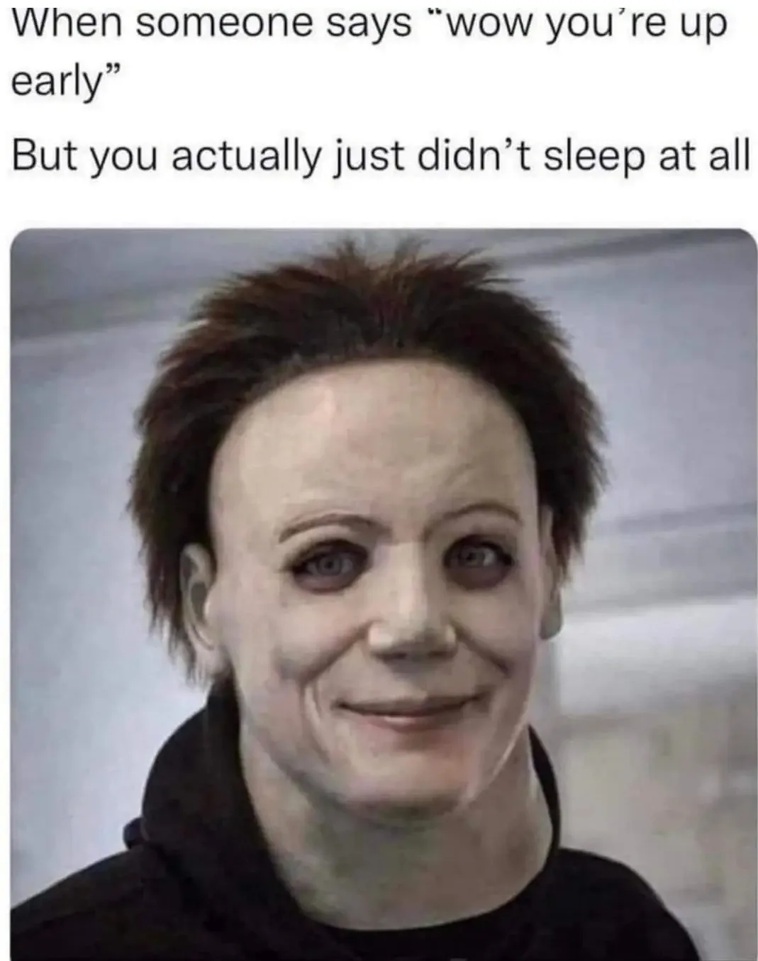 The image shows a close-up of Michael Myers from the Halloween franchise, recognizable by his blank white mask, dark hair…