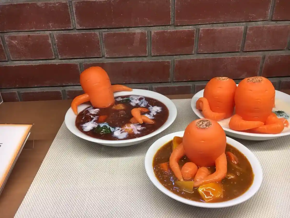 Three bowls of curry feature creatively carved carrots shaped like octopuses, with their 'tentacles' made from smaller…