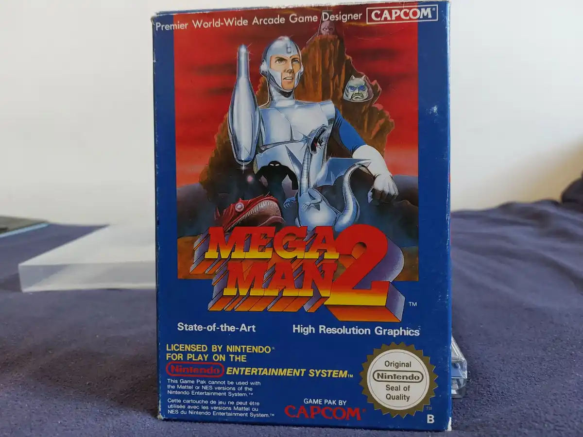 A close-up photo of the physical game box for 'Mega Man 2' for the Nintendo Entertainment System, published by Capcom. The…