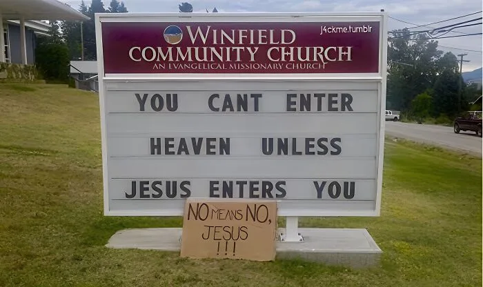 A church sign for Winfield Community Church reads 'YOU CANT ENTER HEAVEN UNLESS JESUS ENTERS YOU', with a cardboard sign in…