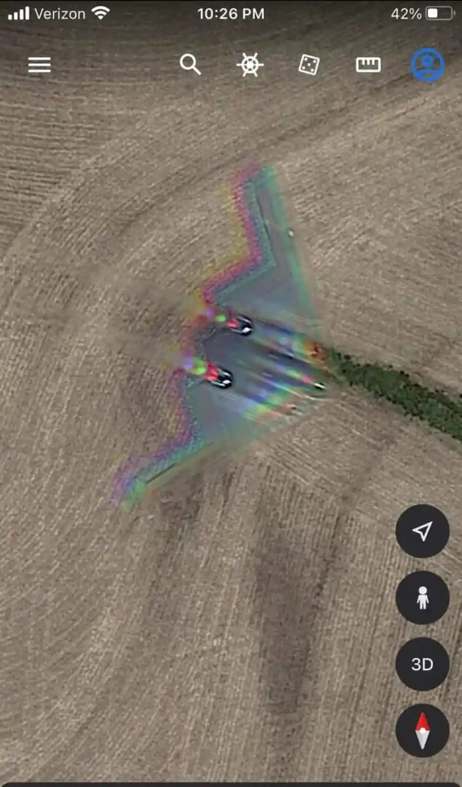 A screenshot of Google Earth shows a field with a distorted, rainbow-hued, triangular shape that resembles a stealth fighter…