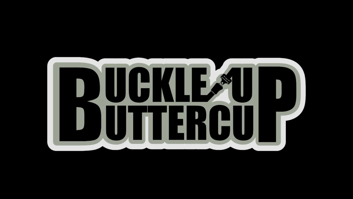 The image displays the phrase 'BUCKLE UP BUTTERCUP' in bold, black, stylized lettering with a gray and white outline against…