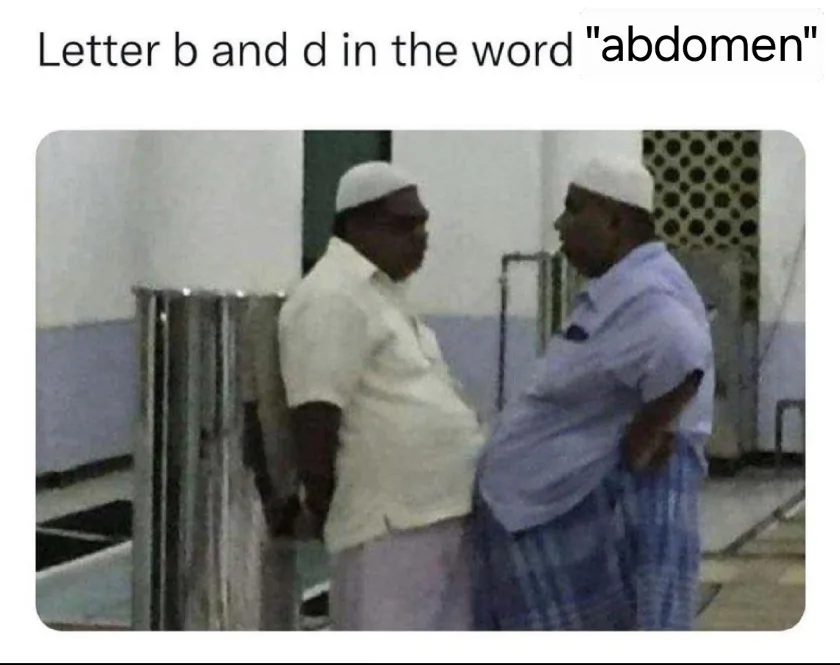 Two men in white caps and loose clothing stand facing each other, both with visibly large bellies. The man on the left wears…