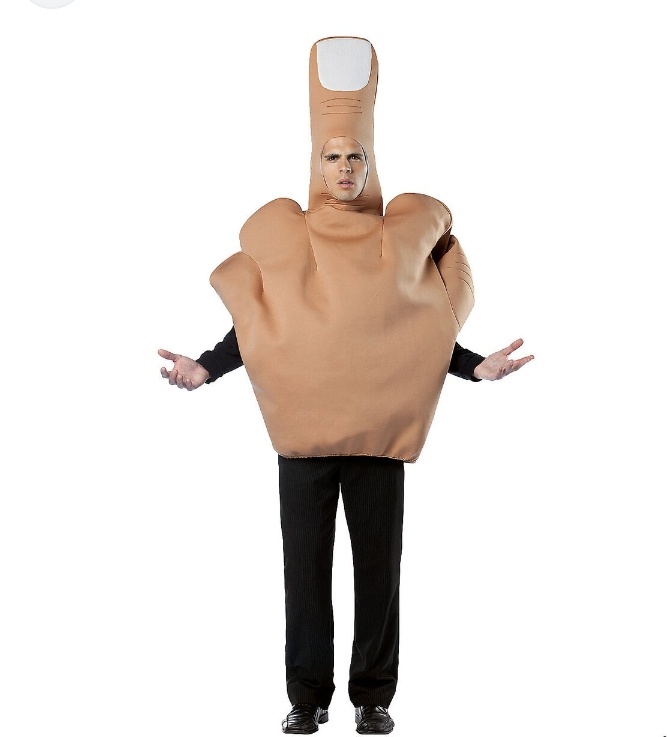 A person wearing a full-body costume shaped like a large, tan middle finger with a white fingernail, standing with arms…