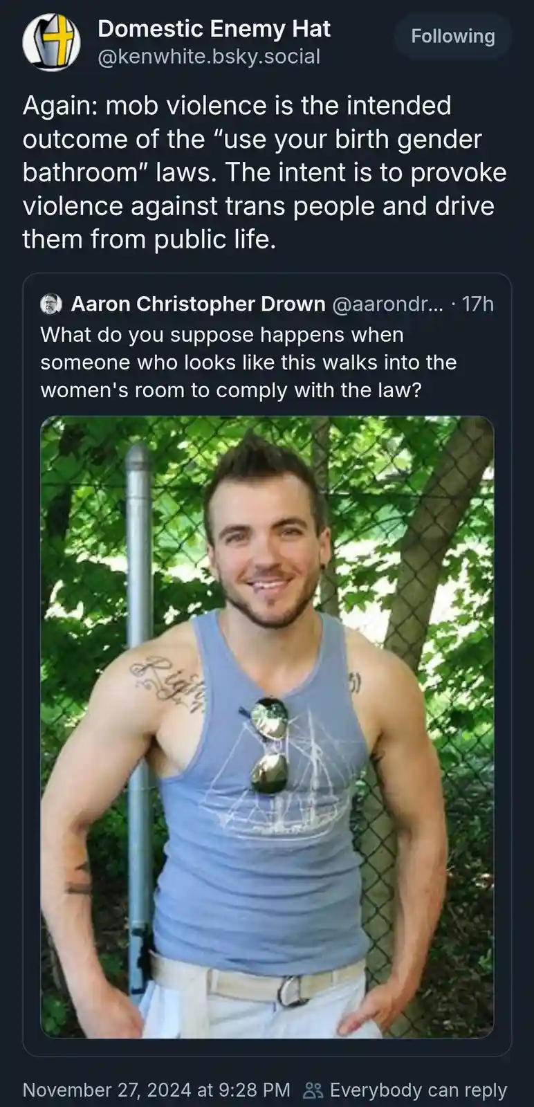 A screenshot of a social media post shows a photo of a smiling, muscular man in a blue tank top with sunglasses hanging from…