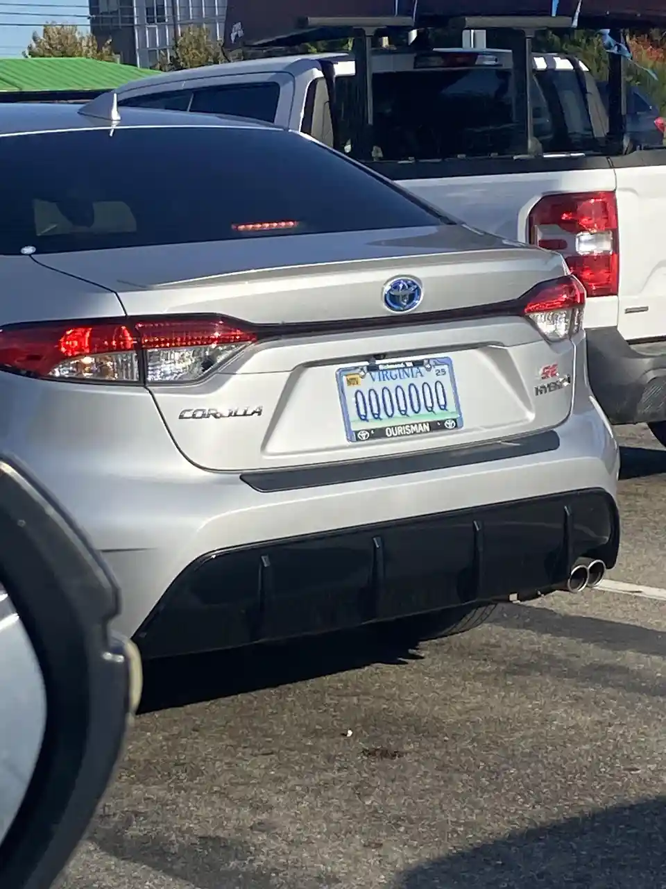 The image shows the rear of a silver Toyota Corolla SE Hybrid parked in a lot, with a Virginia license plate that reads…