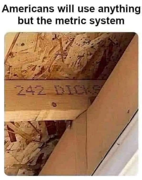 A close-up photo of a wooden beam in a construction site with the words '242 DICKS' visibly stenciled onto its surface…