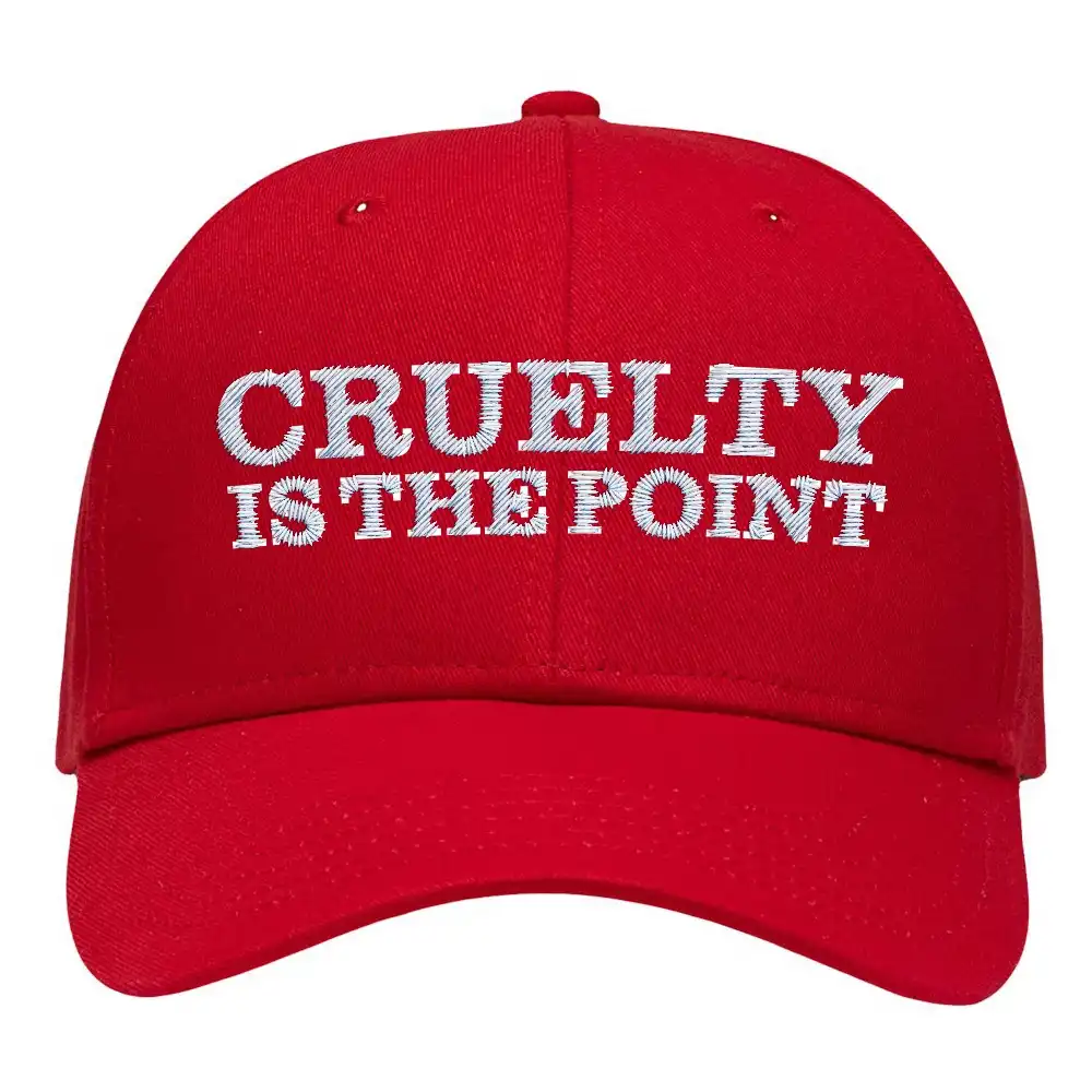 A red baseball cap with white embroidered text that reads 'CRUELTY IS THE POINT' in bold, capitalized letters. The cap is…