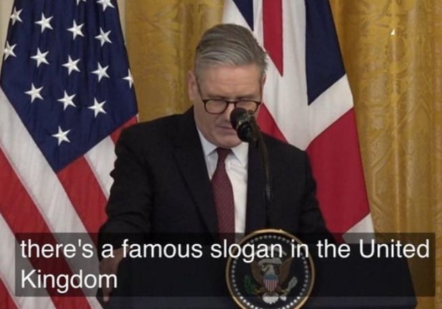 a man in a suit and glasses stands at a podium with the u.s. presidential seal, flanked by american and british flags…