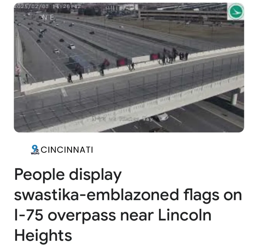 An aerial security camera view shows multiple people standing on the concrete barrier of an elevated highway overpass…
