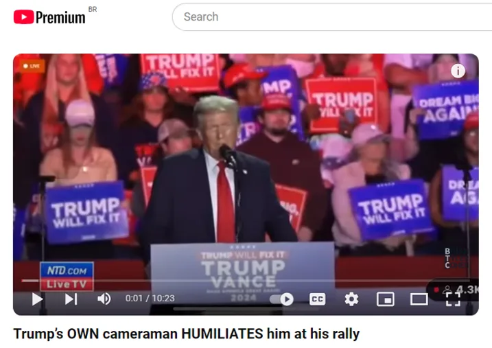 A screenshot from a YouTube video shows Donald Trump speaking at a rally, surrounded by supporters holding signs that say…
