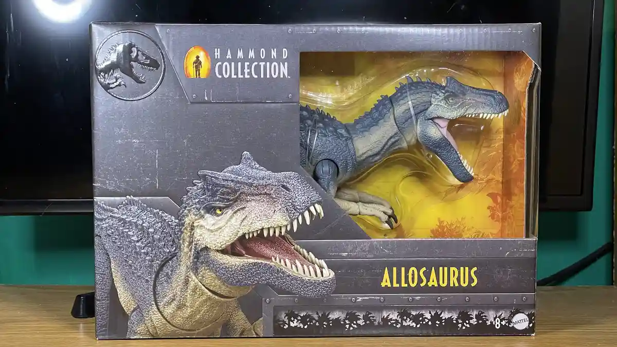 A close-up photo of a Jurassic World Hammond Collection toy box for an Allosaurus, showing the detailed dinosaur figure…