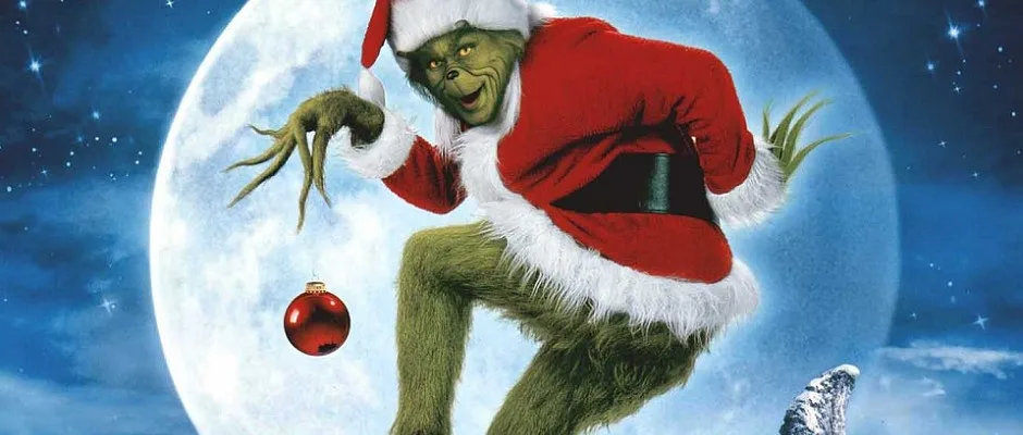 a green, furry creature with a Santa hat and red suit is leaping against a starry night sky with a full moon behind him…
