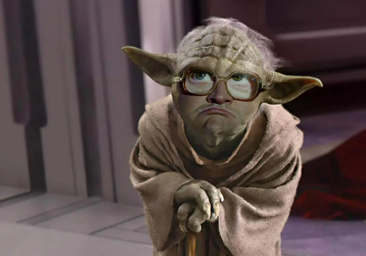 The image shows the character Yoda from Star Wars, digitally edited to wear thick-rimmed glasses and looking upward with a…