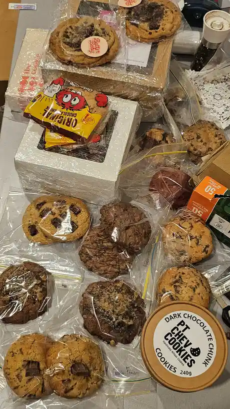 A table is covered with an overwhelming assortment of various packaged cookies, including Butter Baby, Original Chocolate…