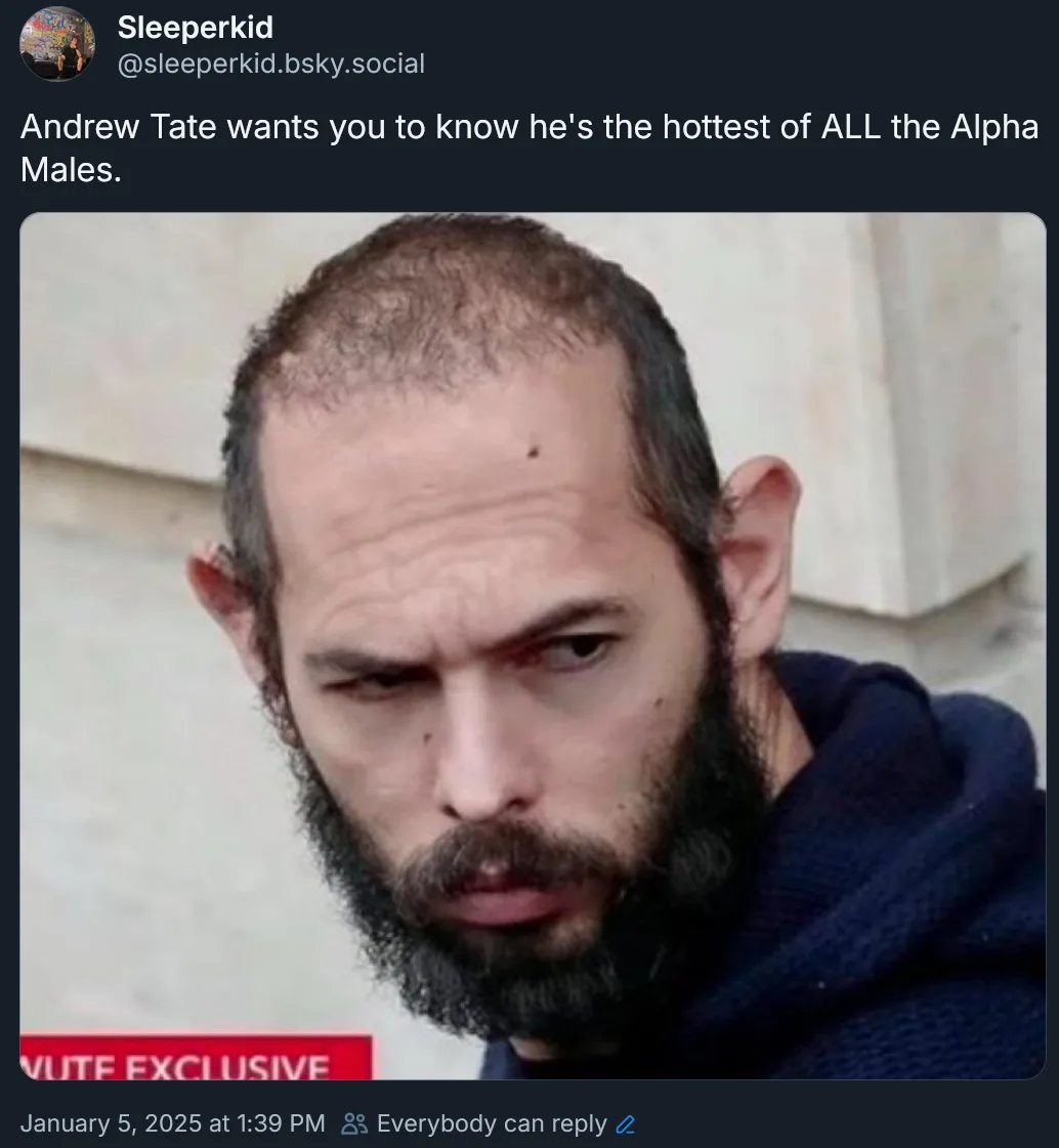 A close-up photo of Andrew Tate with a stern, intense expression, wearing a dark blue hoodie. The overlaid text reads…