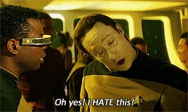 Six panels show a Star Trek character with a forced, exaggerated smile while holding a drink, repeatedly saying 'Oh yes! I…