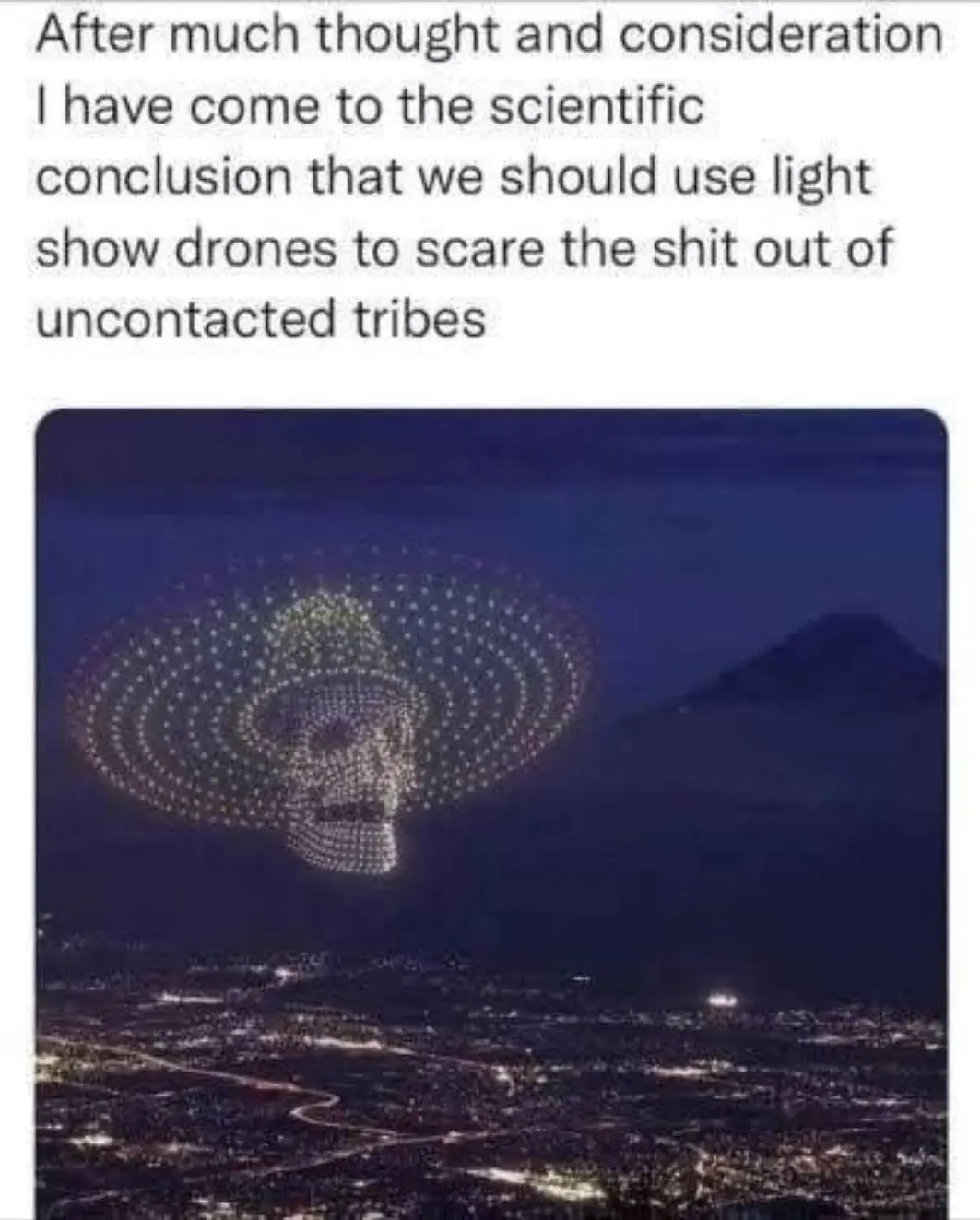 An aerial photo shows a formation of drones lighting up to form a large, glowing skull with concentric rings above a city at…
