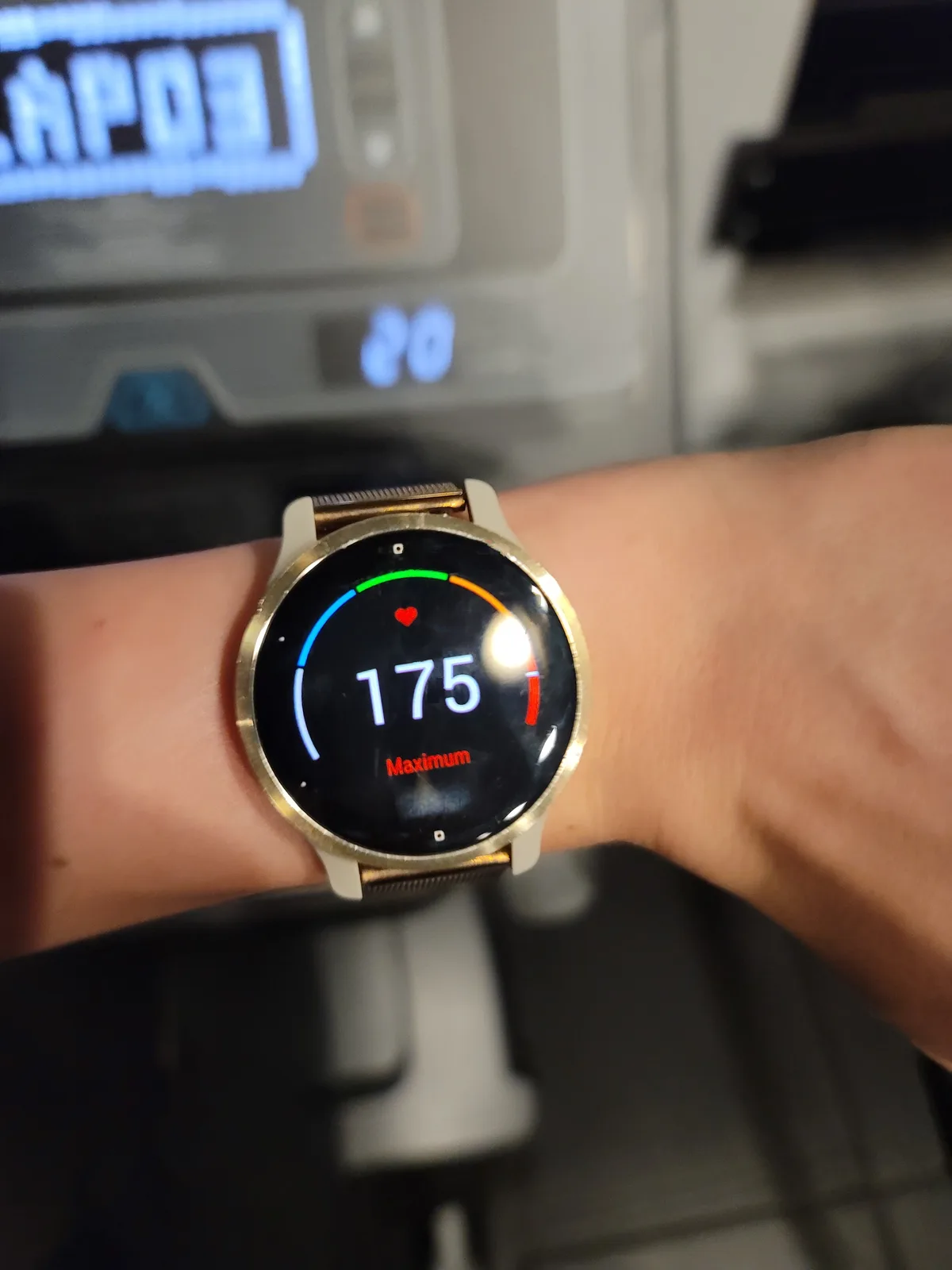 A close-up of a person's wrist wearing a smartwatch displaying a heart rate of 175 with the word 'Maximum' below it…