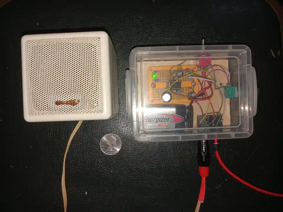 A homemade electronic speaker setup is shown, featuring a white speaker with a perforated grille and a small rusted object…