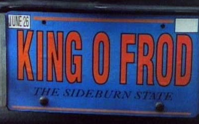 A blue license plate with orange text reads 'KING O FROD' in large letters, with 'THE SIDEBURN STATE' in smaller text below…