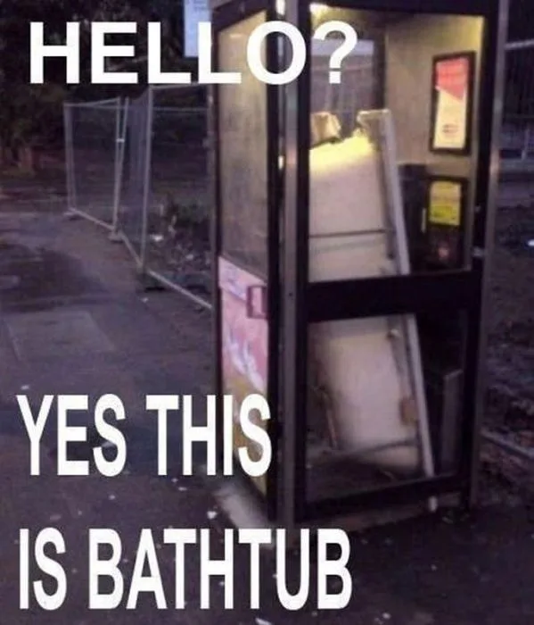 An image of a dilapidated, abandoned public phone booth with its interior visibly empty except for a white bathtub leaning…