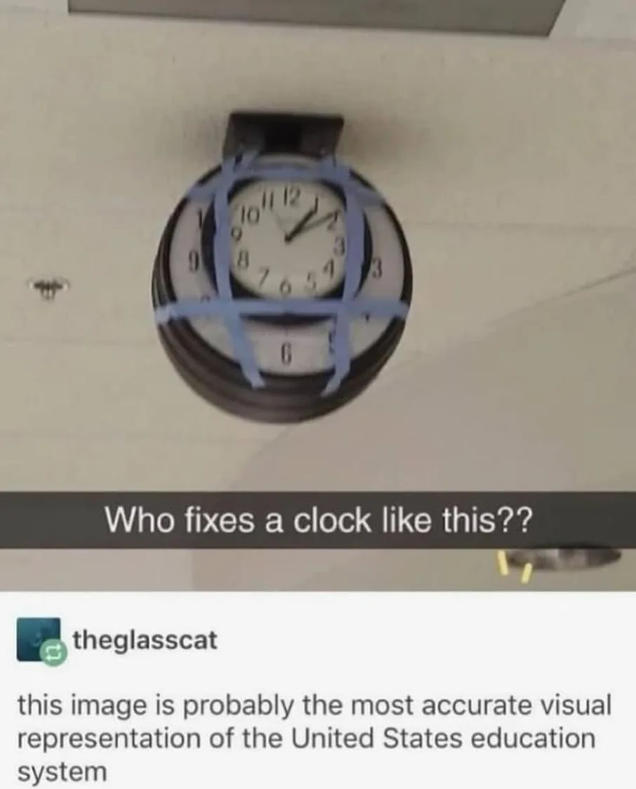 A round analog wall clock is mounted on a ceiling, visibly held together by multiple strips of blue painter's tape…