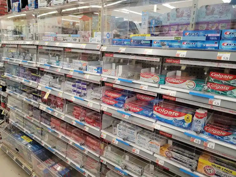 A photo of a Walgreens toothpaste aisle with many clear plastic bins holding various brands like Colgate, Crest, and…