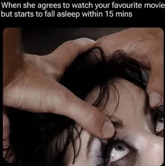 A close-up image shows a person with dark hair and wide, startled eyes, as two hands firmly press down on their forehead…