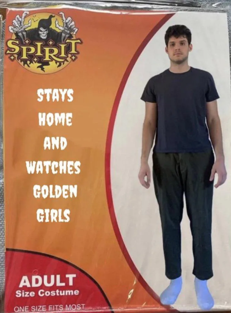 A man in a plain black t-shirt and black pants stands in a Halloween costume package labeled 'SPIRIT' with the text 'STAYS…