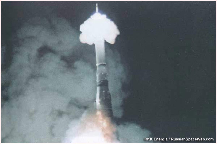 A grainy, low-resolution photo shows a rocket launching vertically into a dark sky, emitting a large, bright plume of white…