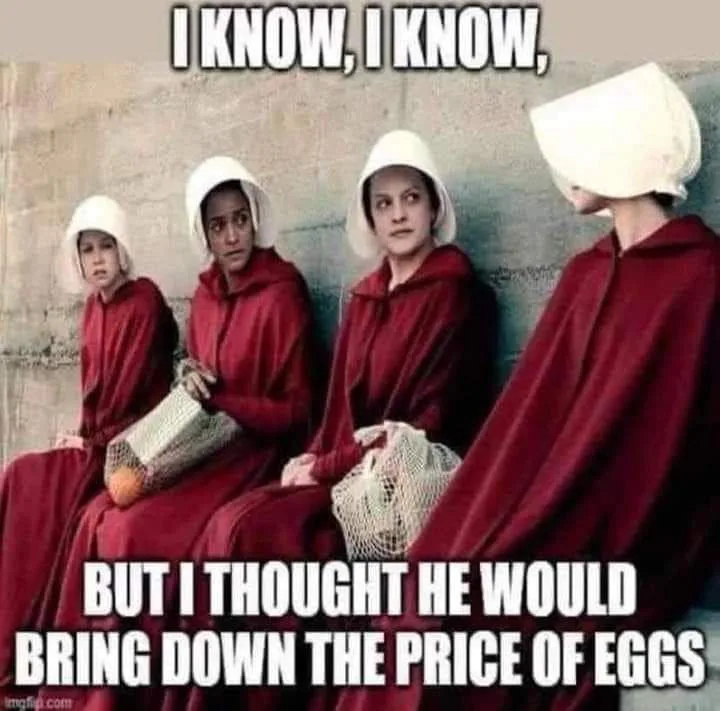 Four women in red robes and white head coverings from 'The Handmaid's Tale' sit against a concrete wall. The text overlaid…